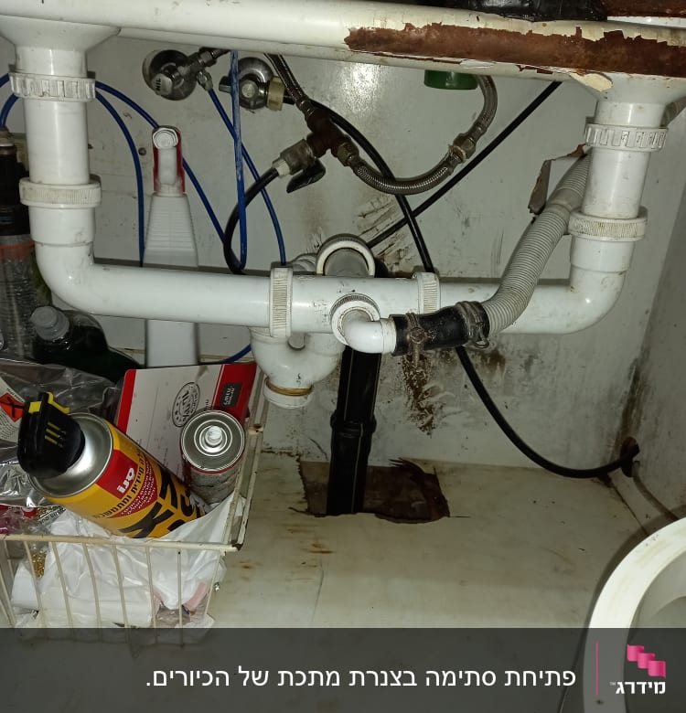 צנרת מתחת לכיור עם חיבורים ודליפה